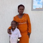 6-year-old Ocira Edmond posing with his mother, Akwero Harriet, at St. John XXIII Hospital Aber after treatment for sickle cell disease, showing parental support and recovery.